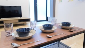 A dining table with four blue bowls on plates, two wine glasses, and a spoon. - Grand Maison Natsumesaka by Tranova (Tokyo)