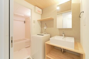 Combined shower/bathtub, hair dryer, slippers, towels