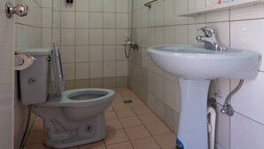 Ein kleines Badezimmer mit Toilette, Waschbecken und Dusche.