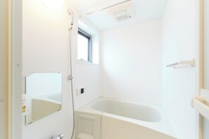 A bathroom with a bathtub, a window, and a mirror. - U Place Shimokitazawa (Tokyo)