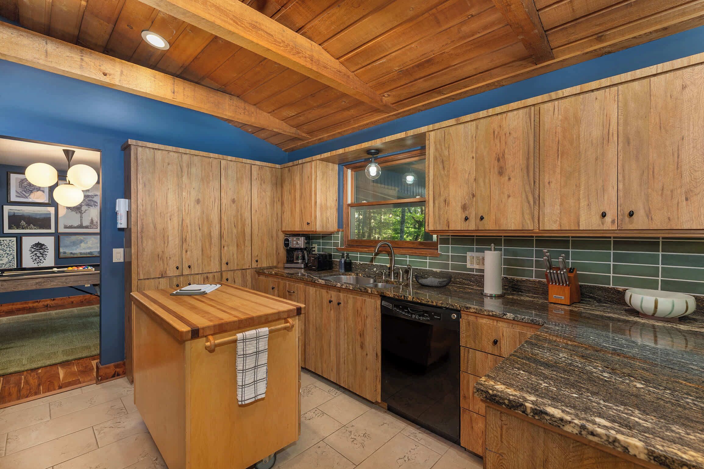 A kitchen with wooden cabinets, granite countertops, and a dishwasher.