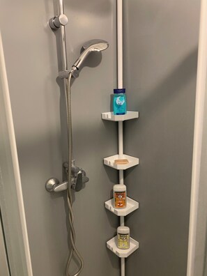 Een douche, handdoeken, zeep, toiletpapier