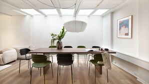 A conference room with a long table, chairs, a vase with flowers, and a framed picture on the wall. - Kings Square 3BR by Daniel&Jacob's (København)
