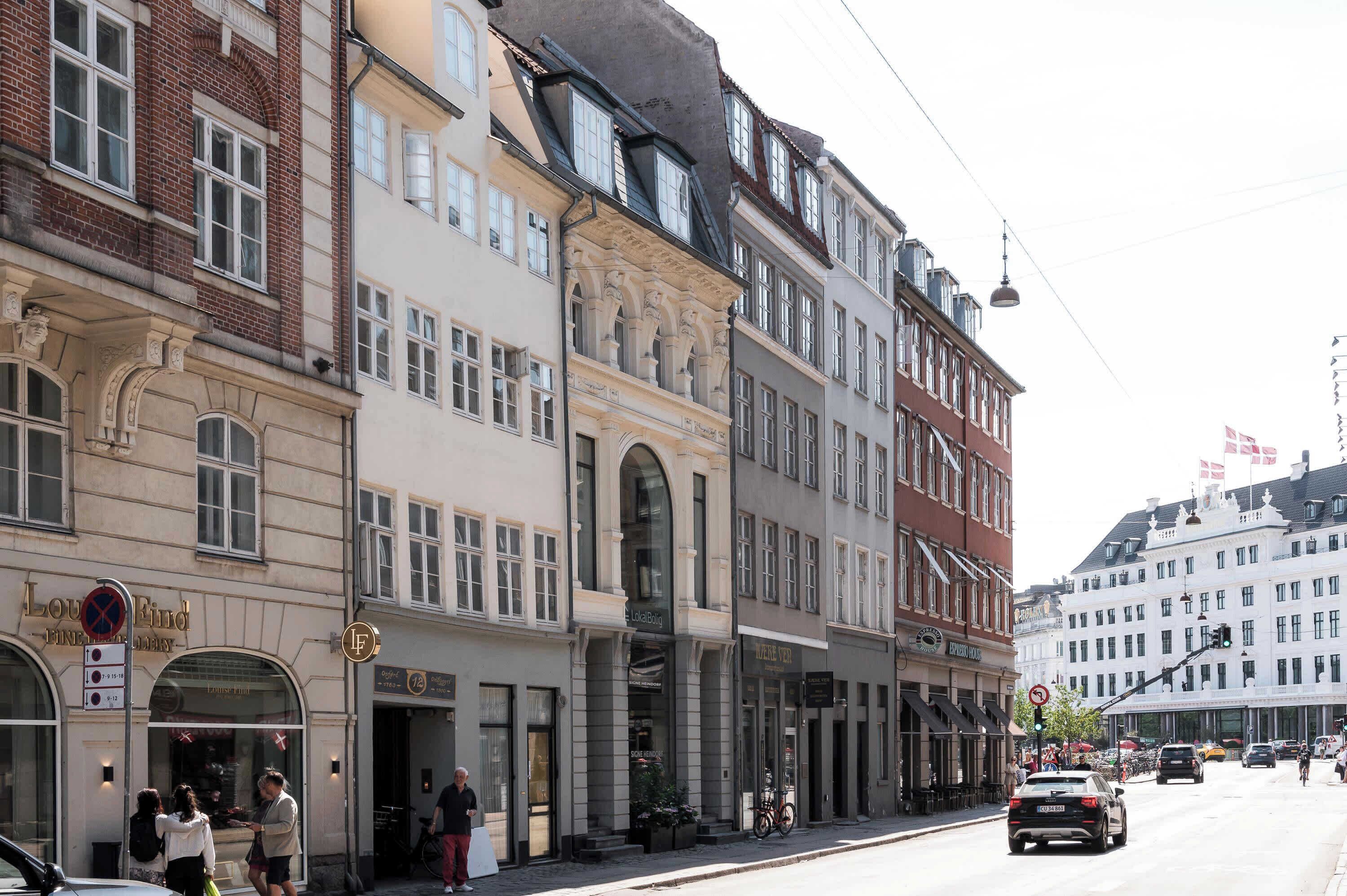 Vista de la calle con edificios históricos, una bicicleta y coches.