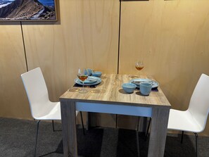A dining table with blue plates, a glass of wine, and two blue cups. - Twizel retreats - GH Cottage (Twizel)