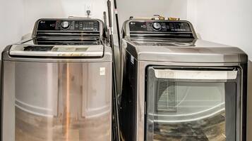 Two stacked laundry machines in a room.