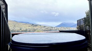 Ein Whirlpool mit Blick auf eine Stadt und Berge im Hintergrund.