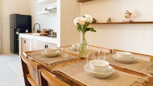 A dining area with a wooden table set for four, surrounded by woven placemats. - Casa Mahina Umalas (Kerobokan)