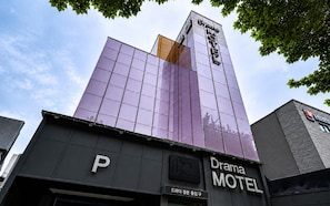 A modern building with a purple glass facade and a sign for 'Drama Motel.' - Daegu Suseong DRAMA (Daegu)