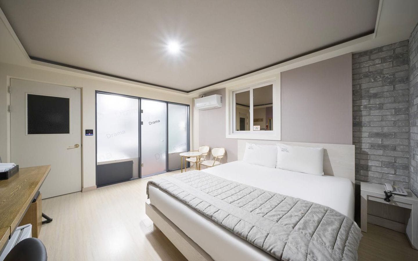 Un dormitorio moderno con una cama grande, un escritorio, una silla y una mesita.