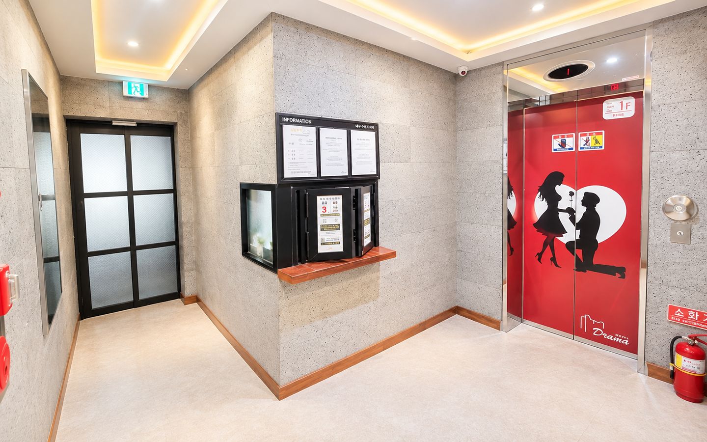 A hotel lobby with a reception desk, information boards, a fire extinguisher, and a red elevator door with a silhouette of a couple.