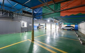 Et indendørs parkeringsanlæg med flere niveauer, afmærkede parkeringspladser og et tydeligt loft.