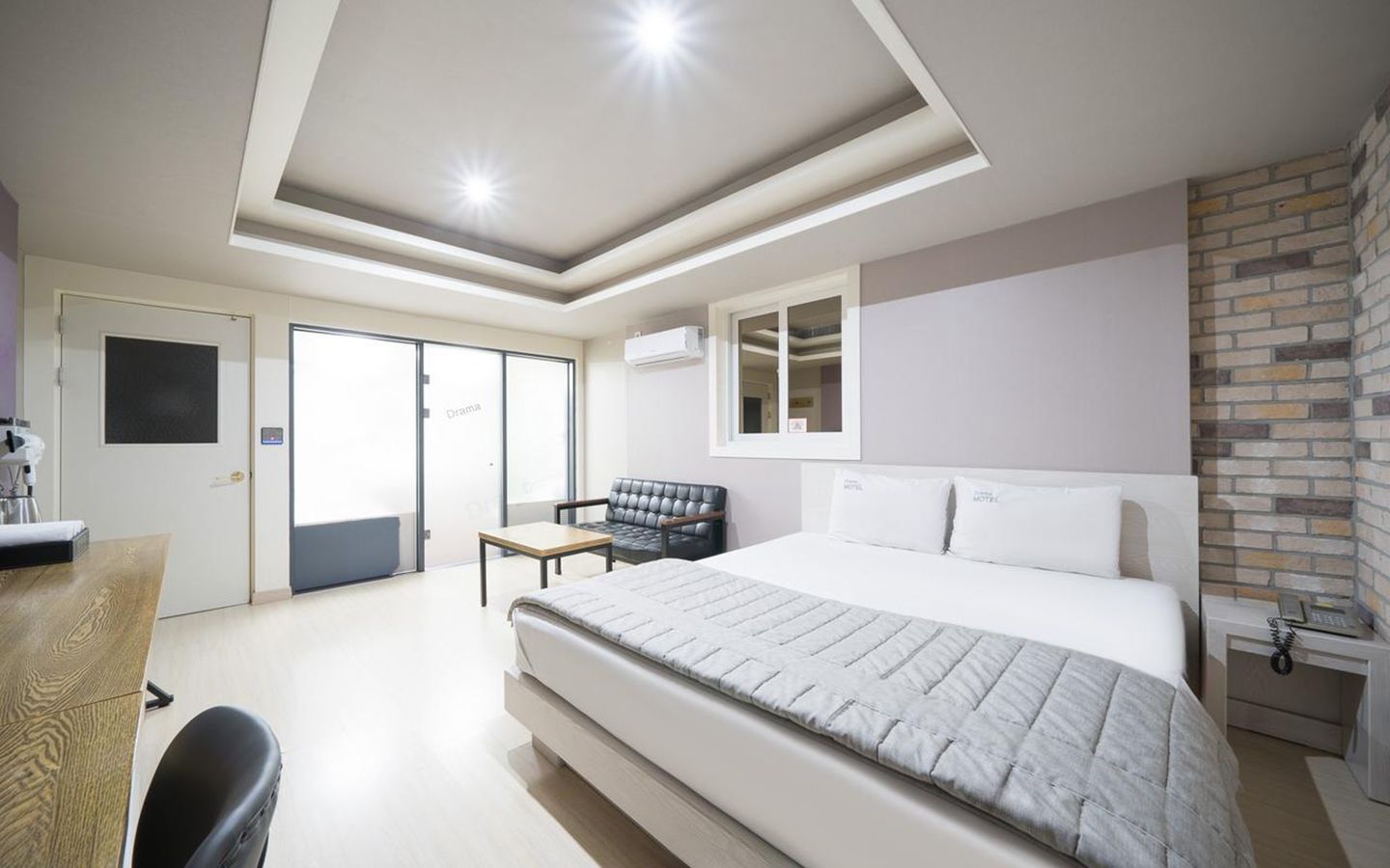 Una habitación de hotel con una cama grande, un escritorio, una silla y un armario.