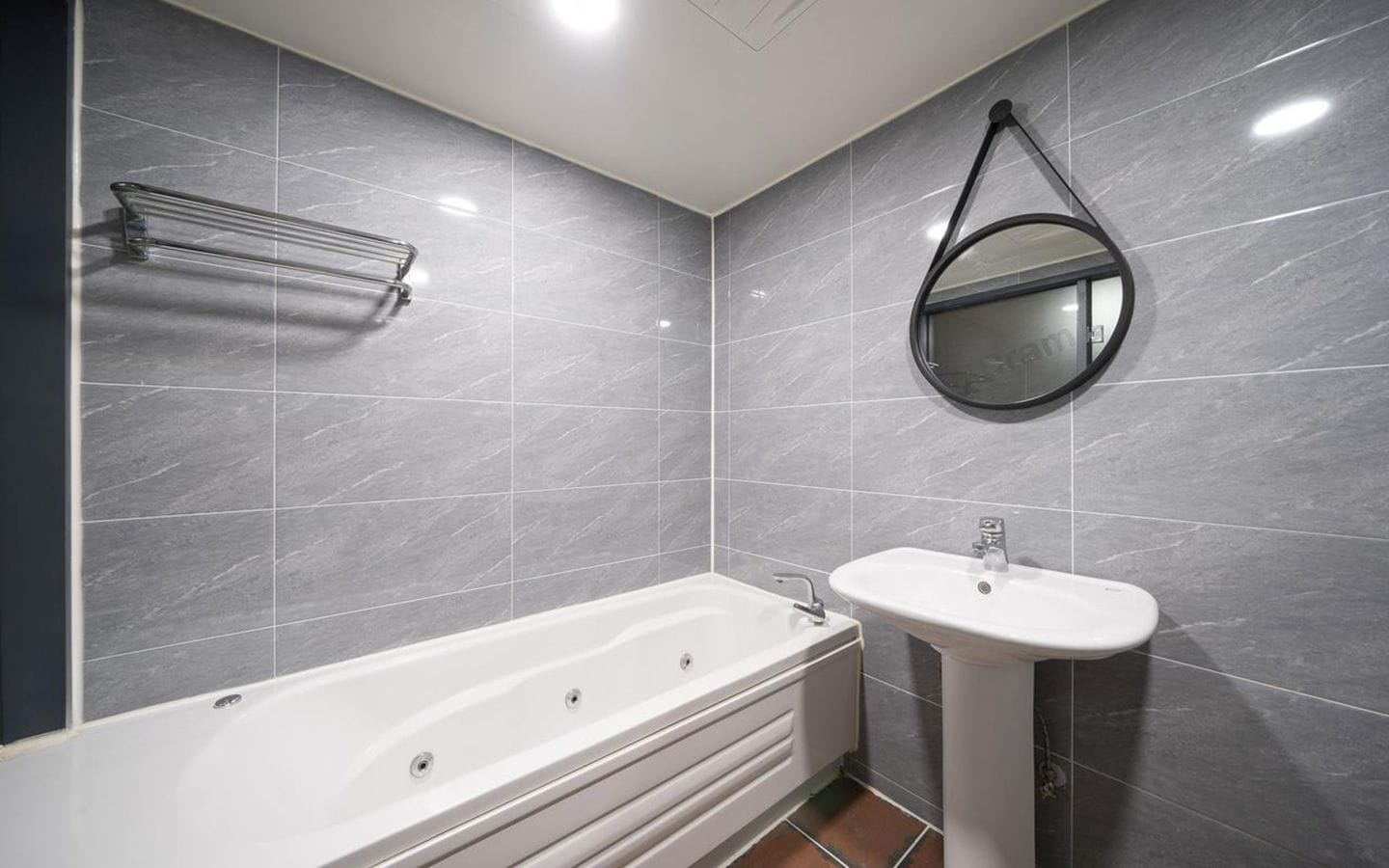 A modern bathroom with a bathtub, a sink, and a mirror.