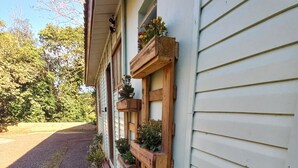 Une maison avec une jardinière en bois fixée sur le côté, contenant diverses plantes et fleurs.