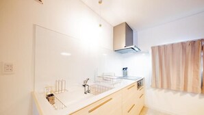 Eine moderne Küche mit weißer Arbeitsplatte, Holzschränken und einer Edelstahl-Dunstabzugshaube.