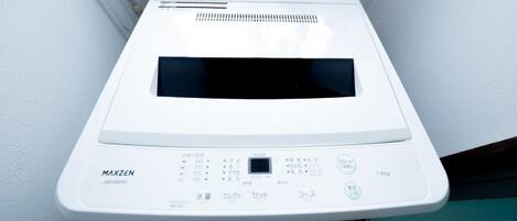 A white, wall-mounted, compact, electric rice cooker with a digital display and multiple control buttons.