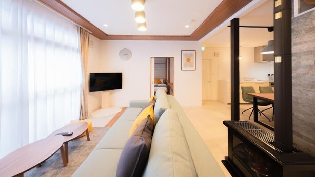 Ein modernes Wohnzimmer mit einer Couch, einem Flachbildfernseher und einem Kamin.