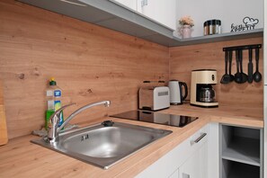 Fridge, stovetop, dishwasher, coffee/tea maker