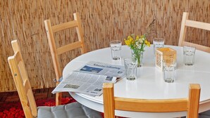 A round table with a newspaper, glasses, and a small vase with flowers. - Holiday Home 'Ferienhaus Am Rander Der Lewitz' with Lake View, Wi-Fi and Air Conditioning (Lewitzrand)