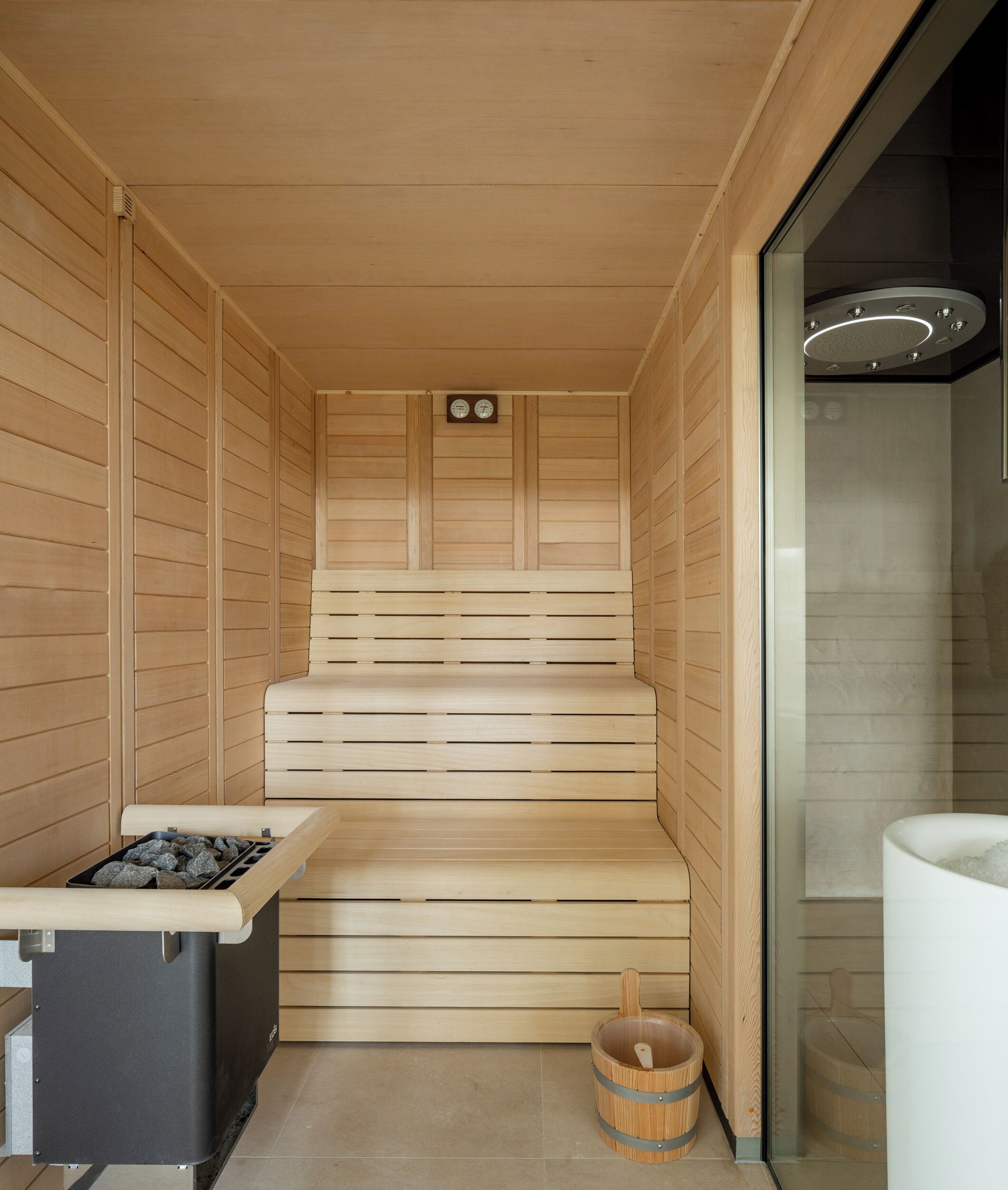 Una sauna con panche in legno, uno scaldasalviette e un catino.