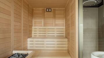 Una sauna con panche in legno, uno scaldasalviette e un catino.