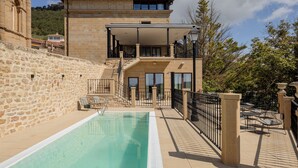 A two-story building with a pool, stone walls, and a balcony. - Hotel Boutique Mirador de Deyo (Villamayor de Monjardín)