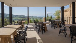 A terrace with tables and chairs, offering a view of the countryside. - Hotel Boutique Mirador de Deyo (Villamayor de Monjardín)