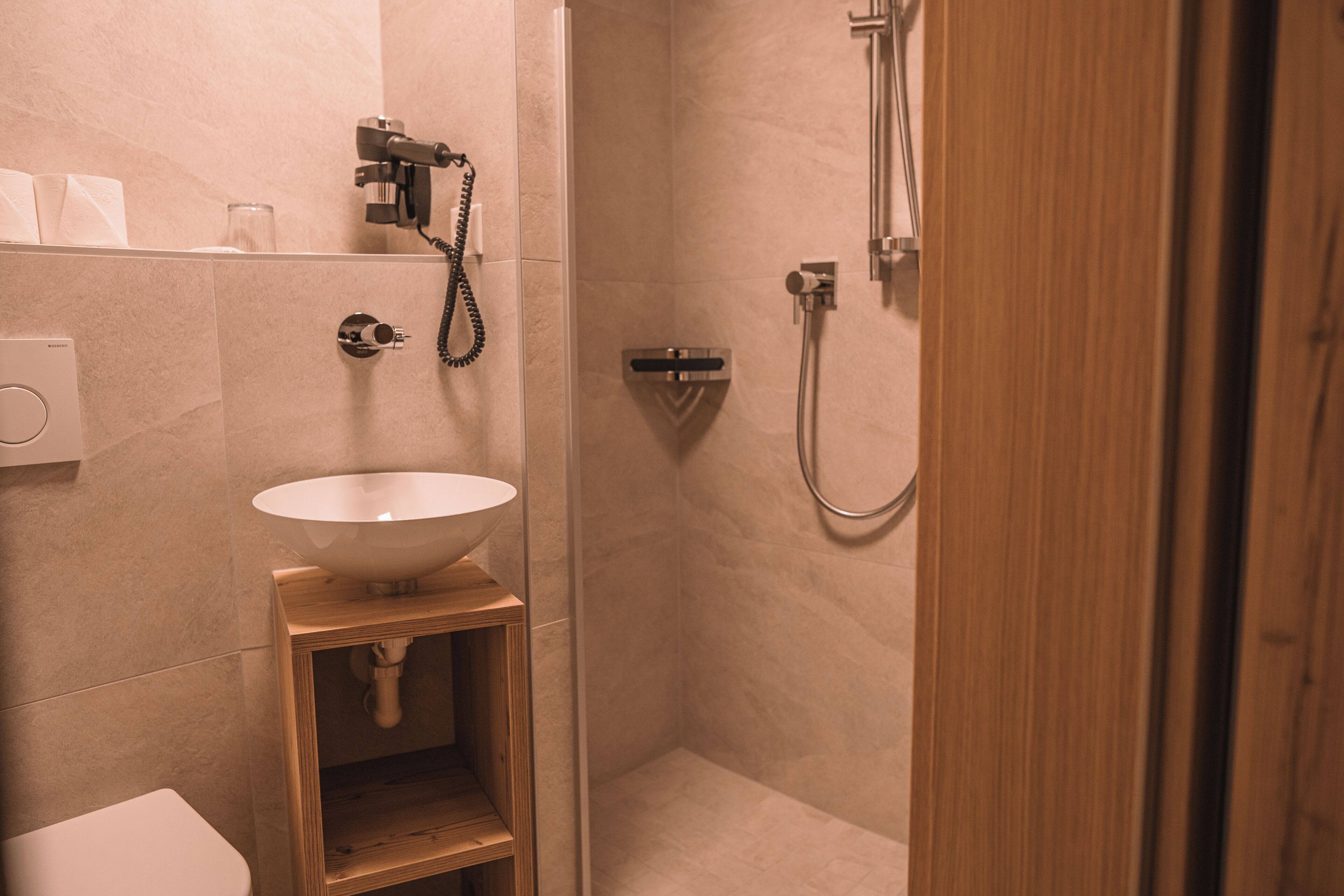 Une salle de bain avec un lavabo blanc, une douche et des toilettes.
