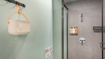 A bathroom with a shower, a hanging basket, and toiletries on the wall.