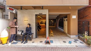 A building entrance with a sign reading 'EIGHT COFFEE' and a bench outside.