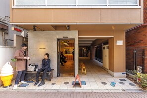 A building entrance with a sign reading 'EIGHT COFFEE' and a bench outside. - Dash Living Shinjuku (Tokyo)