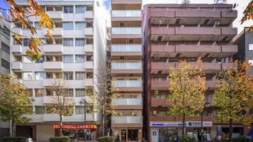 A multi-story building with balconies, a uniform shop, and a Lawson convenience store.