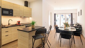 A modern kitchen with wooden cabinets, a black microwave, and a red coffee maker. - Calahonda Beach (Mijas)