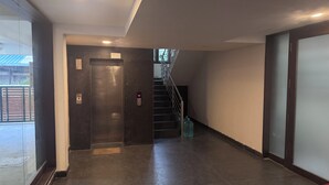 Un intérieur moderne avec un escalier, un ascenseur et un fauteuil rouge.