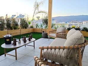 Eine Dachterrasse mit Tisch, Stühlen und einem dekorativen Eiskübel.