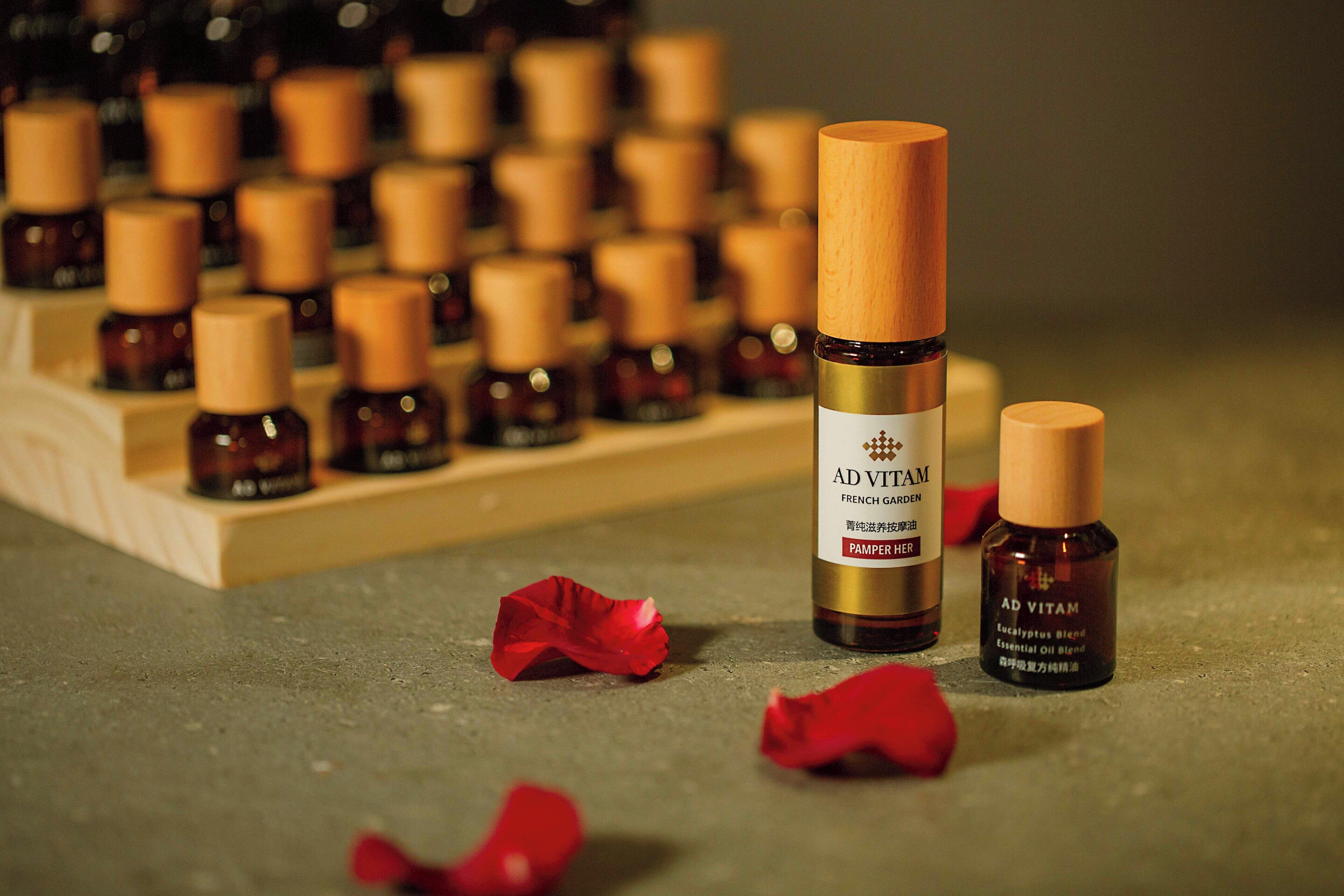 A display of small bottles with wooden caps, one prominently labeled 'AD VITAM FRENCH GARDEN'.