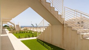 A modern building with a staircase leading to a terrace overlooking a landscaped garden and the sea. - GuestHost - Comfortable 40 sqm apartment, perfect for 4 people, located on the ground floor.The property is located inside the Borgo 81 Residence, a short distance from Marzamemi, and offers a quiet and well-served context, with a shared swimming pool, c (Pachino)