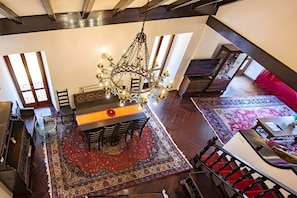 Un espace repas agrémenté d’un lustre, de meubles en bois et de tapis à motifs.
