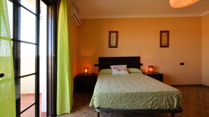 Een slaapkamer met een bed, twee nachtkastjes en een raam met gordijnen.