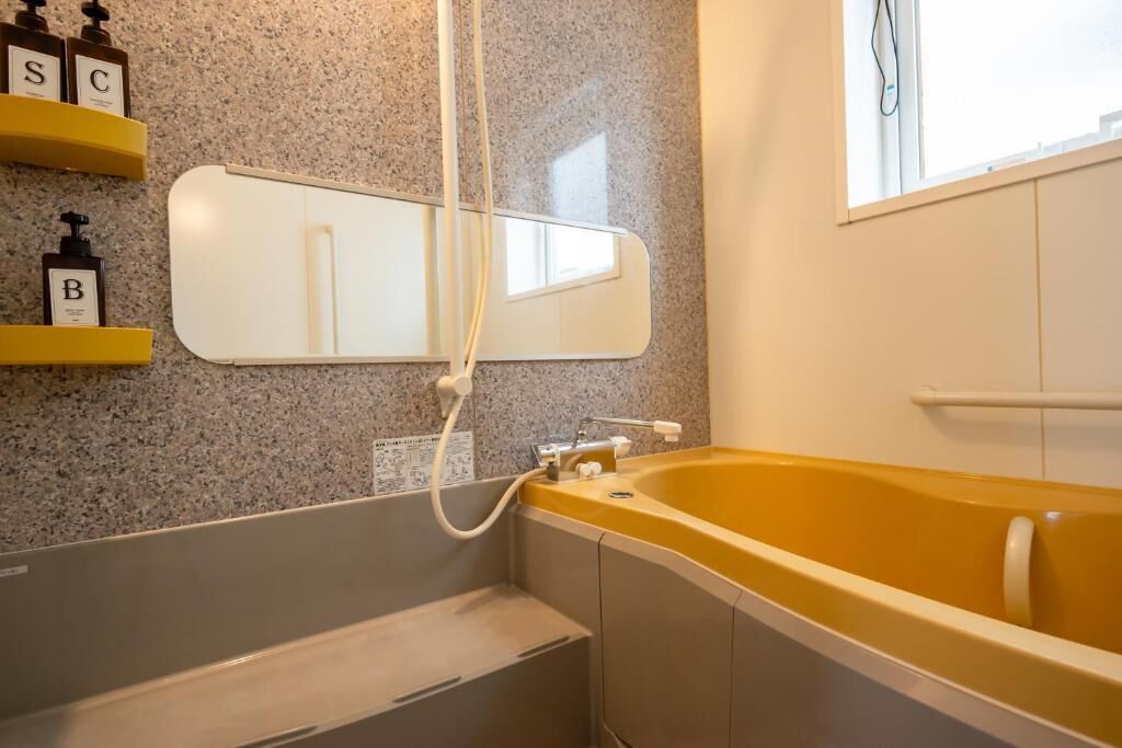 A bathroom with a bathtub, a mirror, and shelves with toiletries.