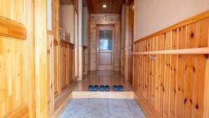 A wooden hallway with a tiled floor and a door at the end.