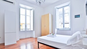 A bedroom with a bed, a wardrobe, and a window. - GuestHost - La Casa del Presepe Central House (Naples)