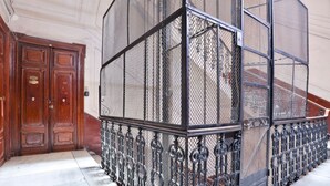 A staircase with a metal railing and a wooden door. - GuestHost - La Casa del Presepe Central House (Naples)