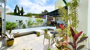 Un patio con una zona de estar, plantas en macetas y vistas del entorno.