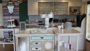 A café with a counter, shelves with glasses, and a chalkboard menu. - Room 'No. 4 with Private Balcony' with Shared Terrace, Shared Garden and Wi-Fi (Mühlenbach)