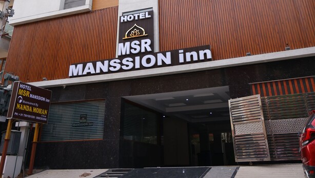 A modern hotel building with a prominent vertical glass window and a sign reading "MSR Mansion Inn". - Nanda Mohan Residency (Tirupati)