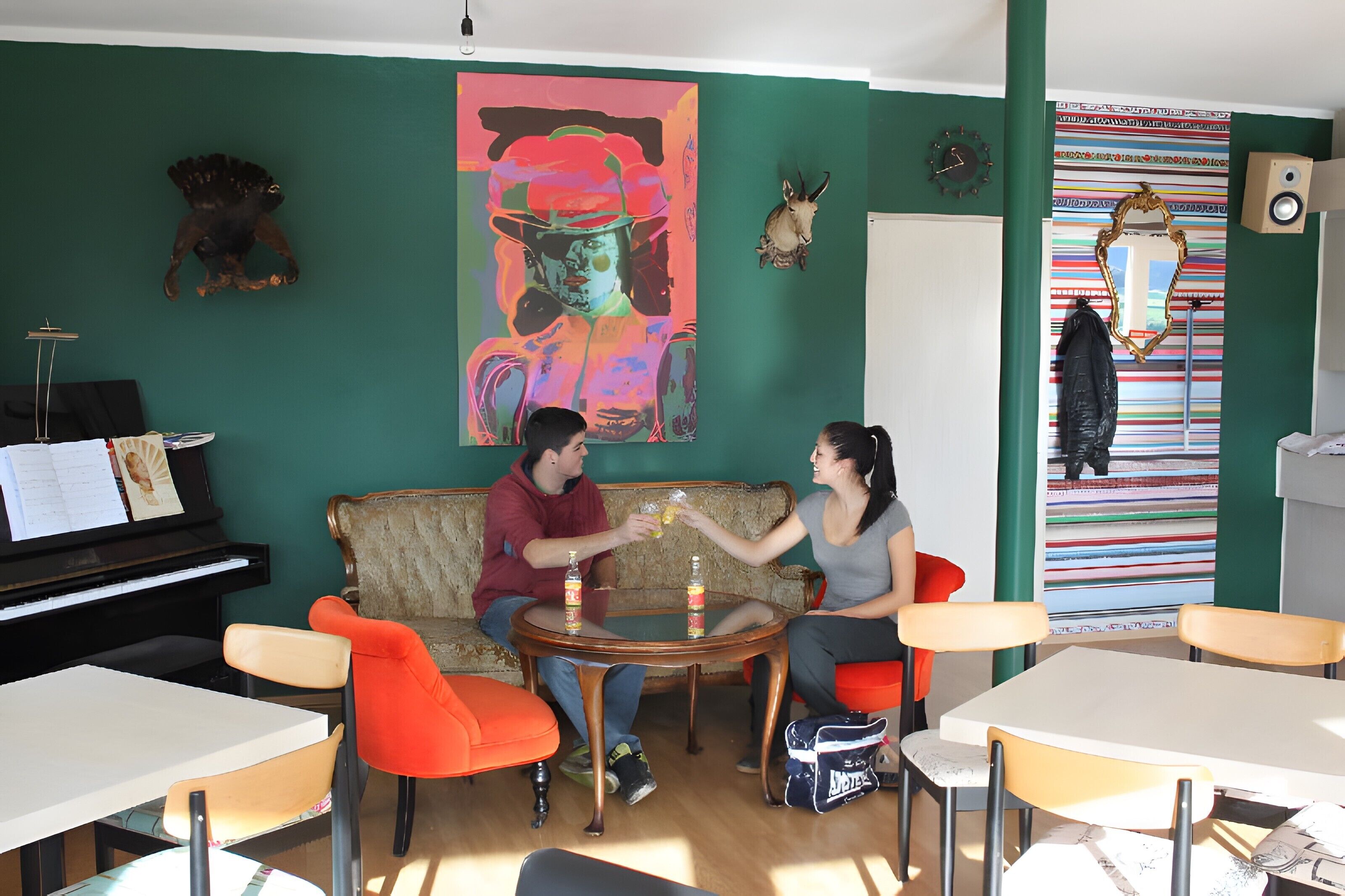 Une pièce avec un piano, un canapé, une table et des chaises.
