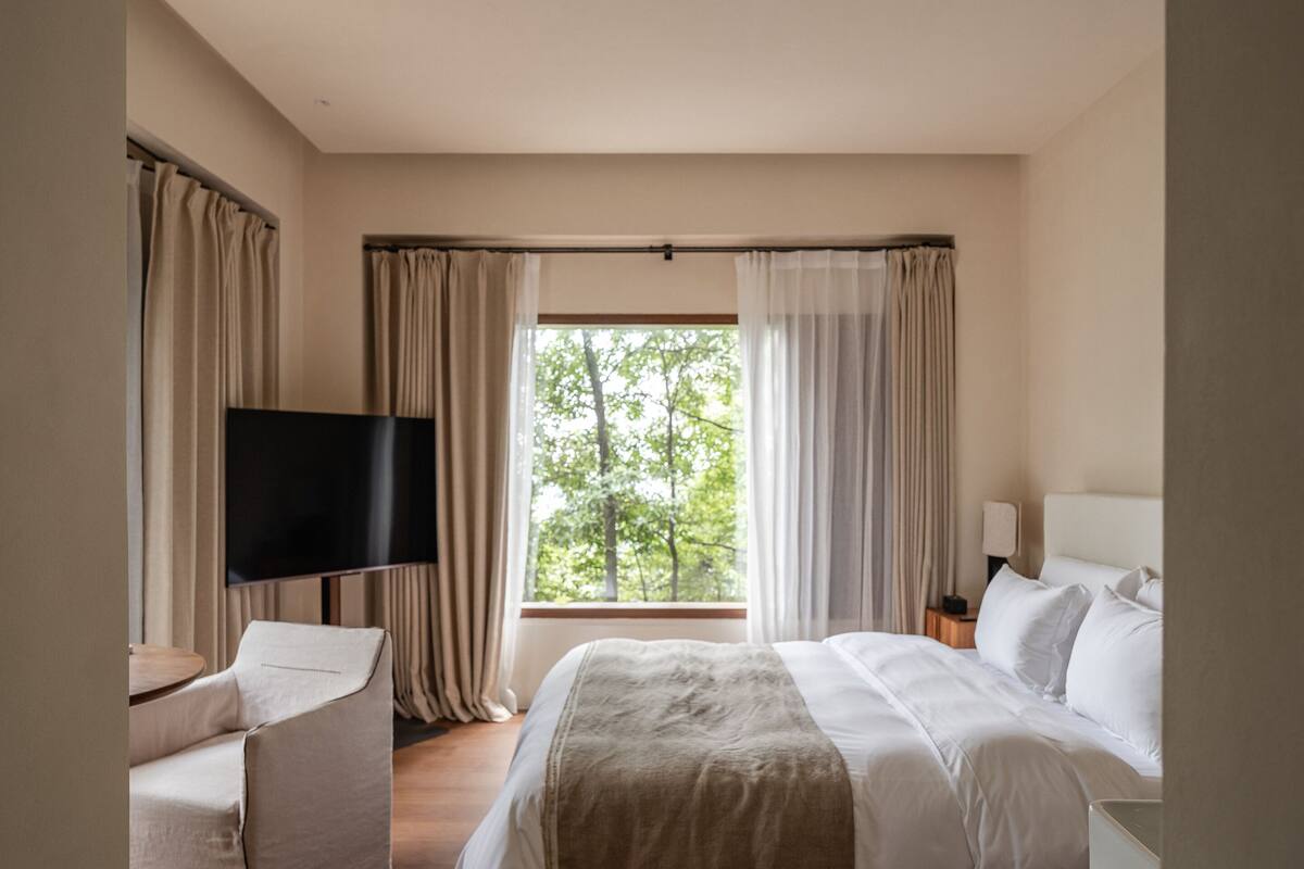 Quarto casal com design assinado, vista para o jardim | Escrivaninha, espaƧo de trabalho para notebook, cortinas blackout