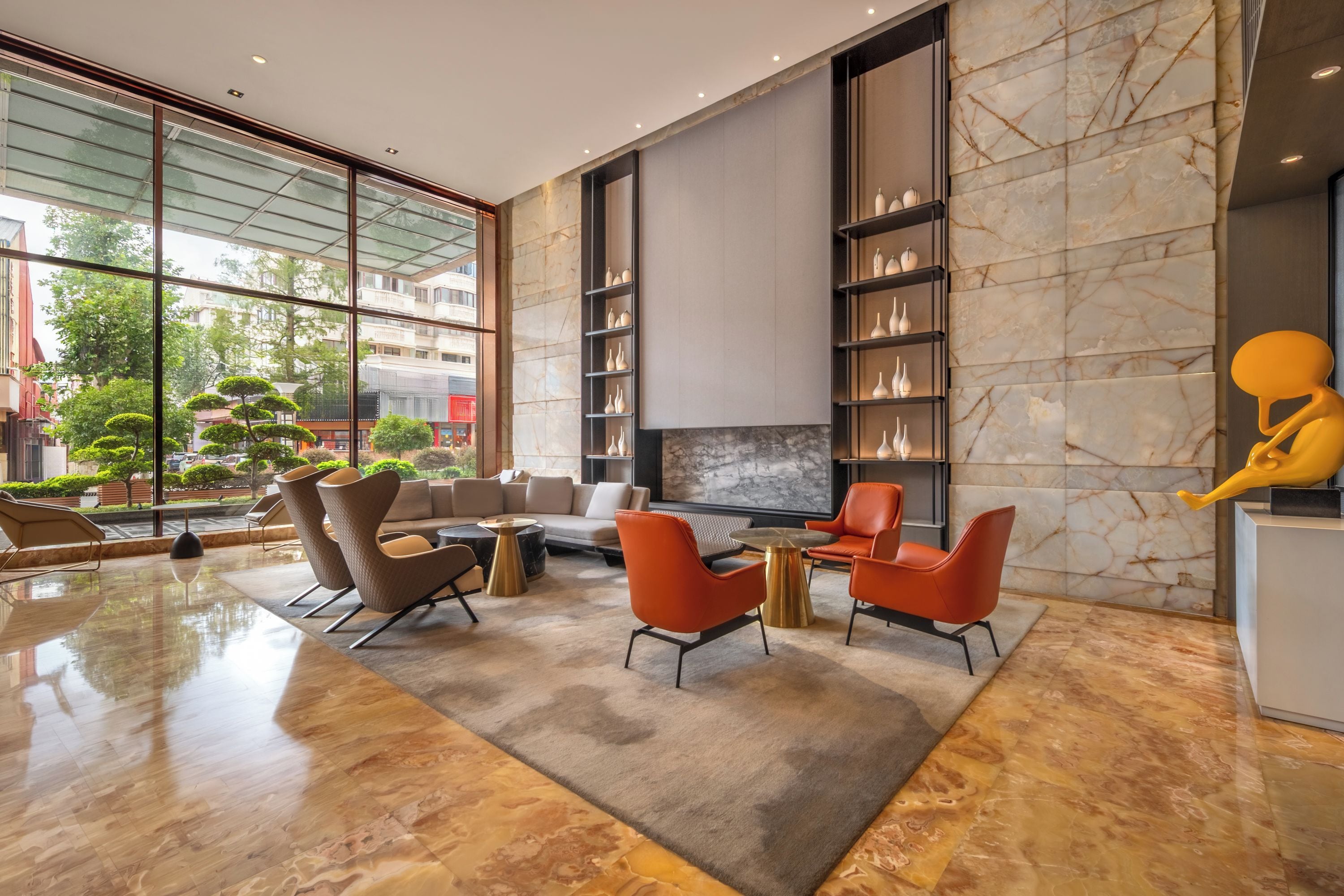 A modern interior with a seating area, a fireplace, and a large window overlooking a cityscape.